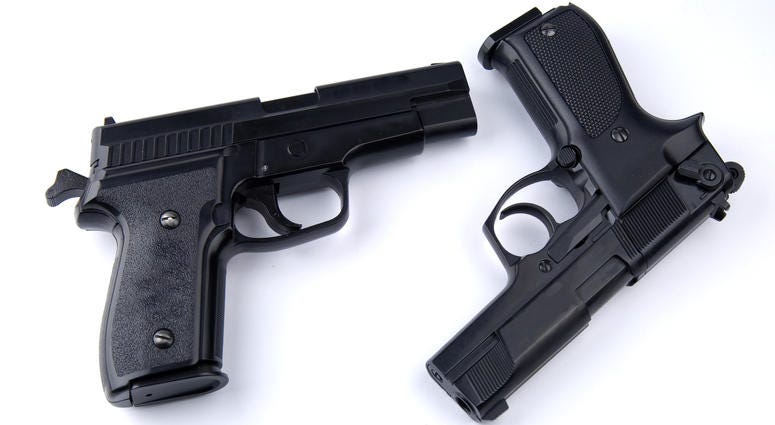 Photo of black guns on the white background