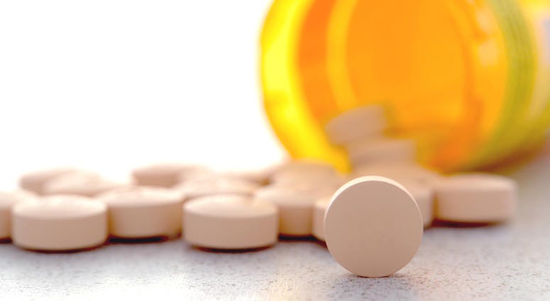 prescription drugs, pills Prescription pain RX medication pills spilled out of an amber pharmacy medicine bottle on a pharmacy counter