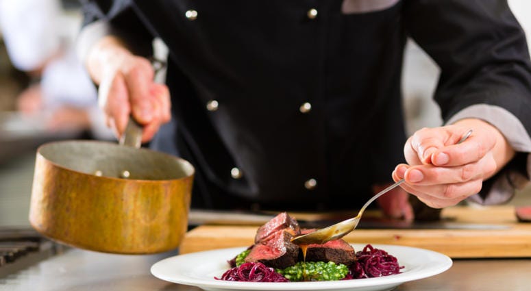 chef, restaurant Chef in hotel or restaurant kitchen cooking, only hands, he is working on the sauce for the food as saucier