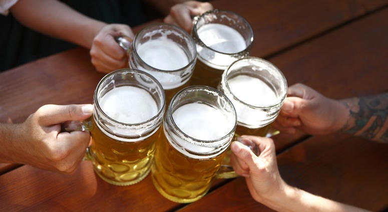 People in traditional costumes drinking beer in a Bavarian beer garden