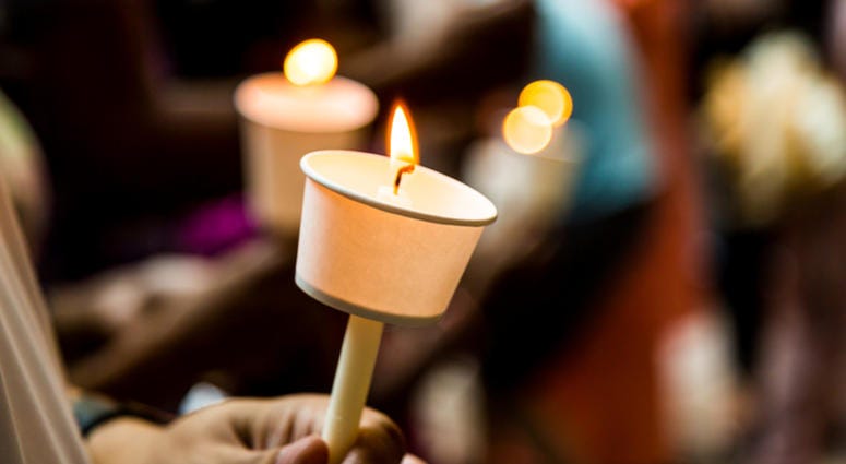vigil Closeup of people holding candle vigil in dark seeking hope