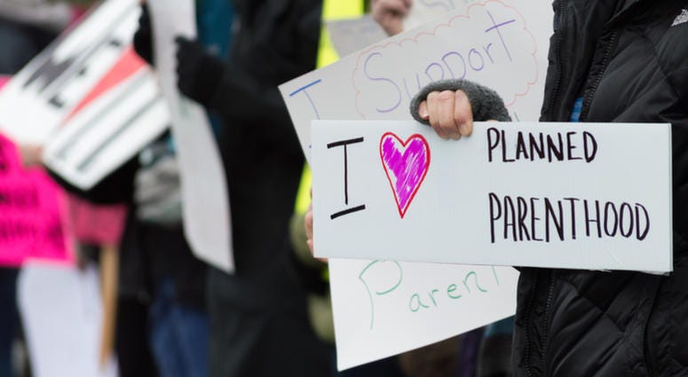 Planned Parenthood, protest A group of people holding signs supporting Planned Parenthood during a pro choice demonstration.
