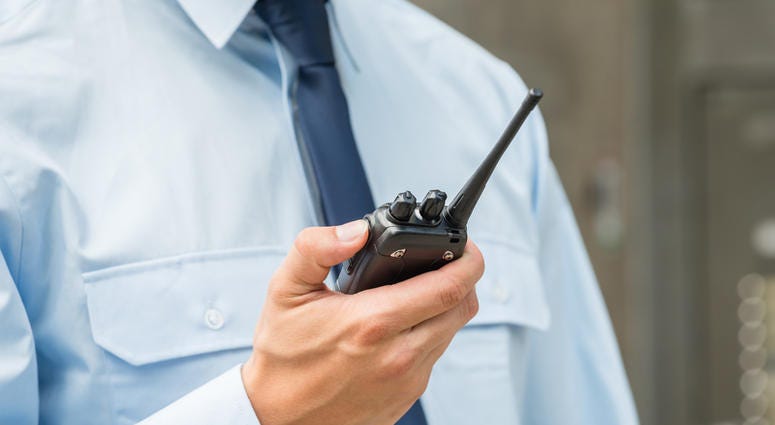 security guard security guard speaks into walkie-talkie