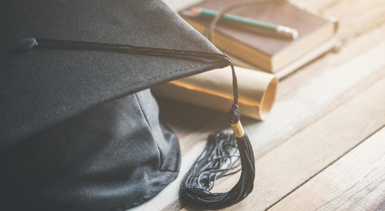 College Graduation cap graduation cap, hat with degree paper on wood table graduation concept.