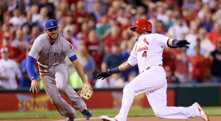 St. Louis Cardinals' Yadier Molina (4) slides safely into third base with an RBI triple ahead of Chicago Cubs third baseman Kris Bryant St. Louis Cardinals' Yadier Molina (4) slides safely into third base with an RBI triple ahead of Chicago Cubs third baseman Kris Bryant