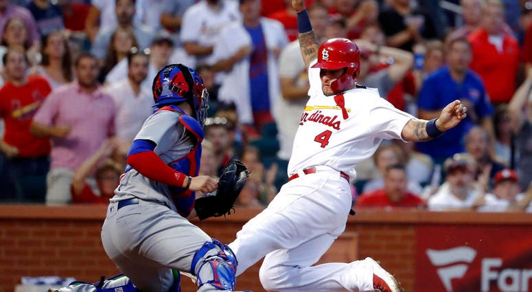 St. Louis Cardinals' Yadier Molina (4) scores past Chicago Cubs catcher Victor Caratini during the third inning of a baseball game Friday, July 27, 2018, in St. Louis.