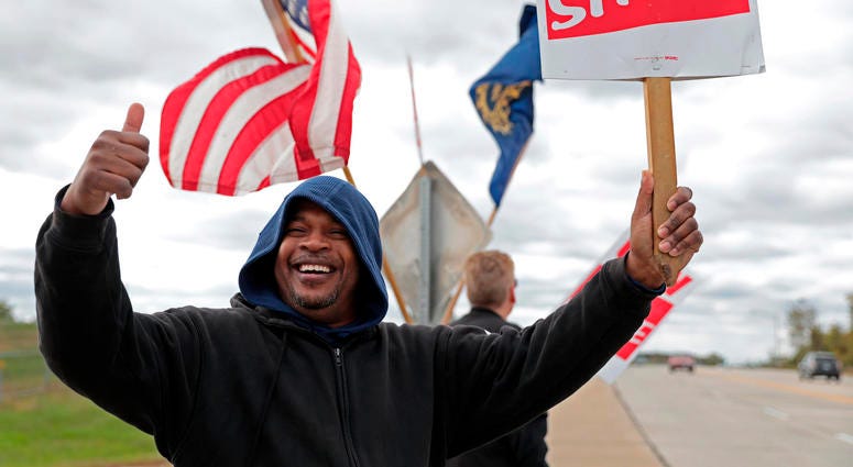 Bill Jackson, of St. Louis, gives a thumbs up to drivers that wave or honk as United Auto Workers outside the GM Wentzville Assembly Center in Wentzville, Mo., Wednesday, Oct. 16, 2019.