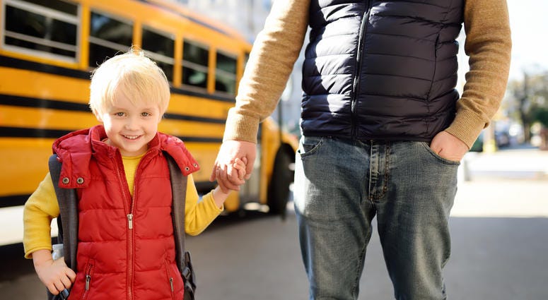 kid with father in front of school bus