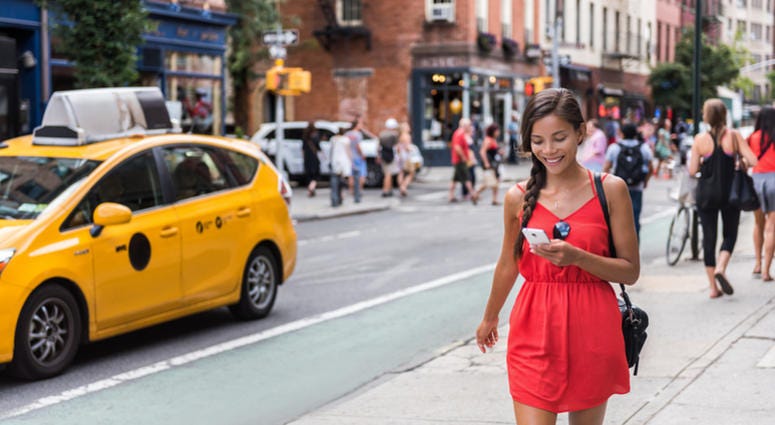 new york, tourist Woman walking in new york city using phone app for taxi ride hailing service or playing online game while commuting from work. Asian girl tourist searching for map directions on smartphone.