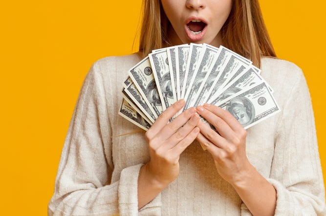 Dos Personas Del Metroplex Ganador Un Millón De Dólares En Raspaditos Amazed young woman holding bunch of money banknotes, celebrating profit over orange background, panorama with copy space