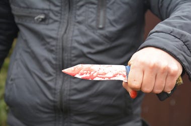 Mujer De Lewisville Fue Apuñalada Mientras Sacaba La Basura Knife attack concept. Murderer, killer is attacking with knife with red fake blood drops.