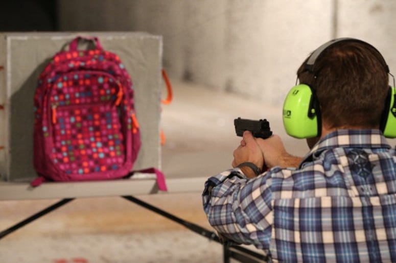 Las Mochilas Antibalas Ya Se Venden En Dallas Chief Operating Officer for Amendment II, Rich Brand, shoots a child's backpack with their Rynohide CNT Shield in it on December 21, 2012 in Salt Lake City, Utah. Their orders for the bulletproof shield have gone up dramatically since the school shooting