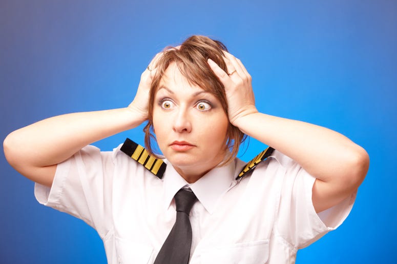 Pasajera De Avión Golpea Novio Por Ver A La Azafata Worried woman pilot wearing uniform with epauletes looking ahead, standing on blue background