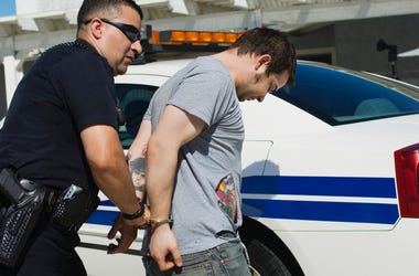 Detenidos 8 Hombres Que Se Prostituían En Fort Worth Mature police officer arresting drug dealer with car in the background