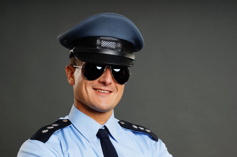 Policía Hace Pachanga En Patrulla Con Amigas, Alcohol y Reggaetón Portrait of smiling policeman in sunglasses on the gray background