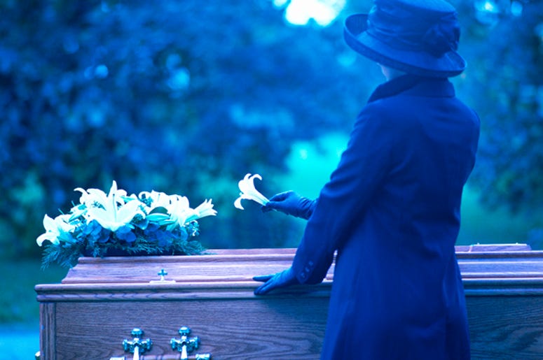 Una Perdida Familiar Más Para La Familia De La Mujer Asesinada En Su Casa Por Un Policía De Fort Worth a woman placing a flower on a coffin