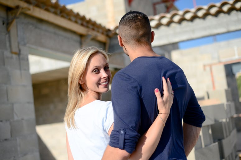 Mujer Construye Bar En Su Jardín Para Que Marido No Se Vaya Con Sus Amigos cheerful young happy couple in love in front of contruction site of their new house