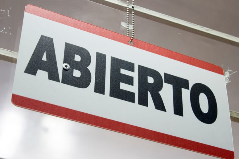 Lista: Restaurantes Abiertos Para Entrega A Domicilio O Para Llevar An spanish open sign hanging in a store. Abierto meaning open.