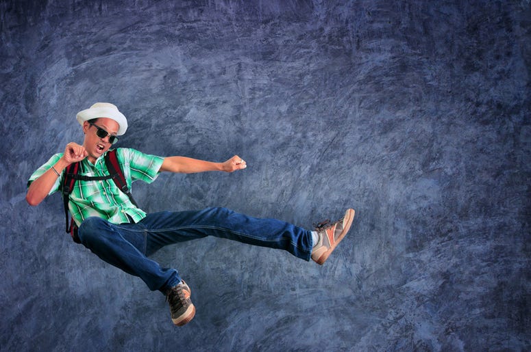 Con Una Patada Voladora Tumba Al Ladrón Que Robaba Su Cartera Traveling man jumping mid air with exciting emotion against cement wall