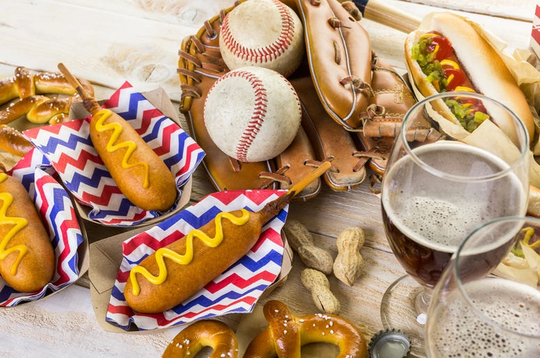 Nuevas Y Engordativas Comidas En Los Juegos De Los Texas Rangers Baseball party food with balls and glove on a wood table.