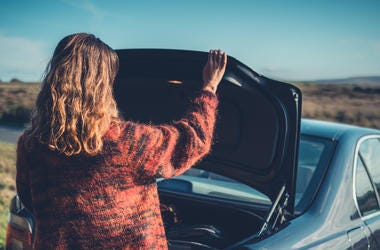 Mujer Escondida En La Cajuela Del Carro Espiaba A Su Esposo A young woman is opening the trunk of her car in the wilderness