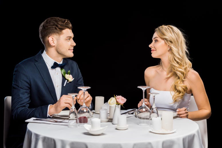 Novios Reparten La Comida De Su Boda En Un Hospital Infantil handsome groom and beautiful bride sitting at served table isolated on black - stock photo