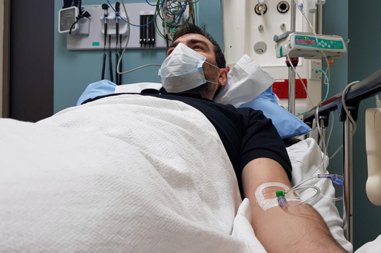 Dreamer De Dallas Con Cáncer Podría Ser Deportado Young man lying in hospital bed. Recovering in modern hospital wards, covered with blanket, face mask and with intravenous needle in his arm