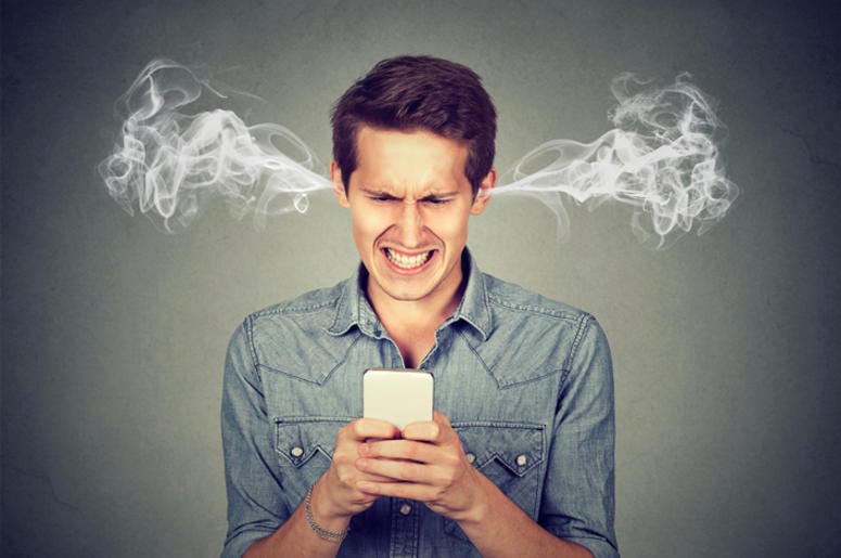 Compañía De Dallas Pagara A Sus Clientes Por Mentirles Frustrated angry man reading a text message on his smartphone blowing steam coming out of ears