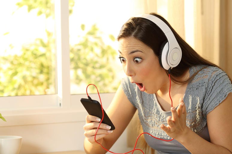¿Escuchas Yanny o Laurel? El Audio Que Tiene Loco Al Internet Amazed woman listening music finding offers on line in a smart phone in her room