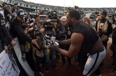 Oakland Raiders defensive end Clelin Ferrell (96) gives his cleats to a fan after the Raiders final game against the Jacksonville Jaguars at the Oakland-Alameda Coliseum before relocating to Las Vegas...