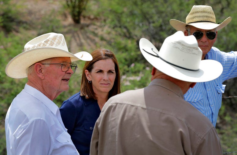 U.S. Senatorial candidate U.S. Rep. Martha McSally, R-Ariz., stands at the international border with Mexico, with ranchers Jim Chilton, left, Ted Noon, center, and Tom Kay, right, south of Arivaca, Ariz.