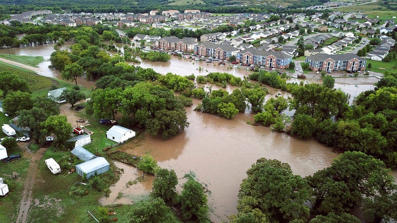 Heavy rain caused a creek to burst its banks and flood Manhattan, forcing more than 300 people to evacuate their homes.