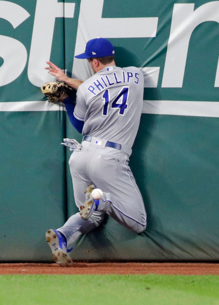 Kansas City Royals' Brett Phillips crashes into the wall while chasing an RBI double