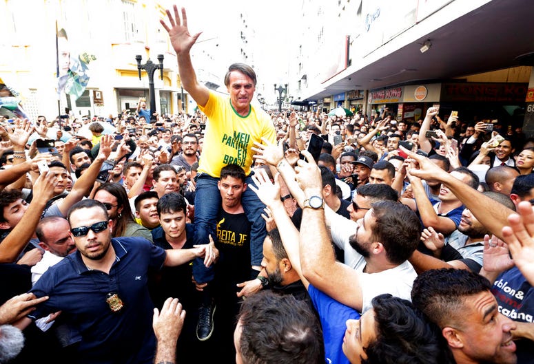 Jair Bolsonaro is taken on the shoulders of a supporter moments before being stabbed during a campaign rally in Juiz de Fora, Brazil