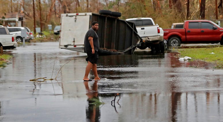 A man walks in the street of his heavily damaged neighborhood in the aftermath of Hurricane Michael
