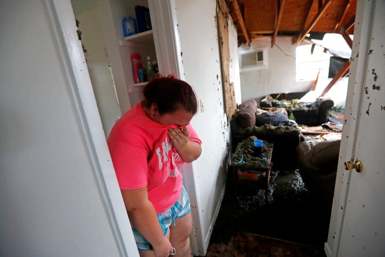 Kaylee O'Brian weeps inside her home after several trees fell on it during Hurricane Michael in Panama City