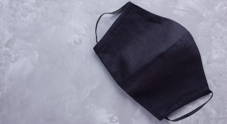 A black face mask on a gray background
