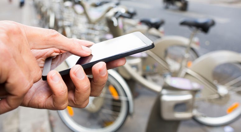 Man renting bike through a smart phone app