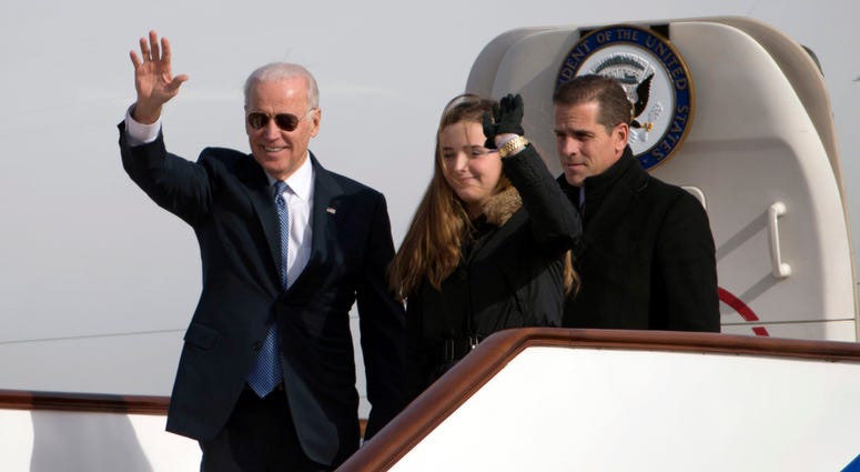 U.S. Vice President Joe Biden waves as he walks out of Air Force Two with his granddaughter Finnegan Biden and son Hunter Biden (R) on December 4, 2013 in Beijing, China.