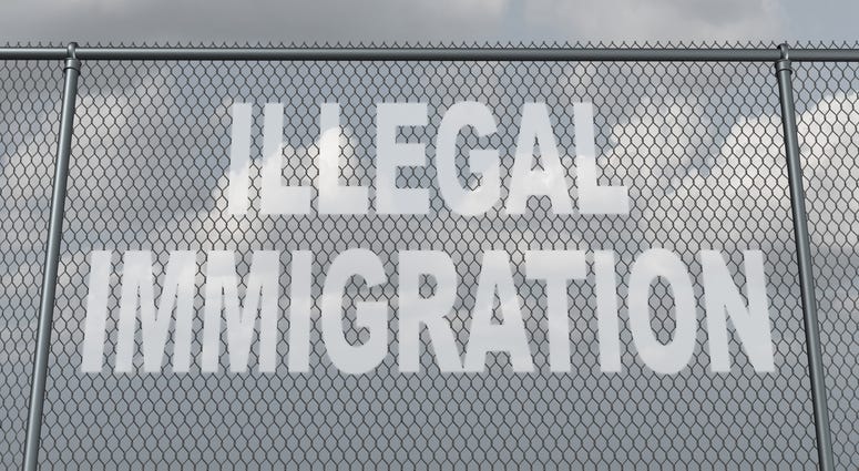 chain fence with a hole shaped as text that represents people illegally crossing a national border violating the migration law of the country