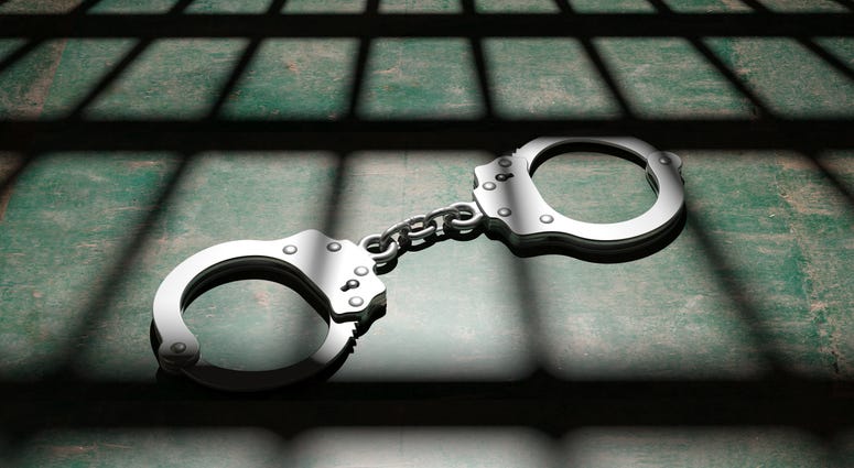 Jail bars and metal handcuffs on the floor