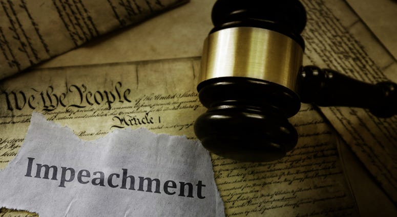 Impeachment message on pages of the US Constitution with legal gavel