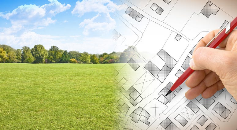 Construction plans- concept image with hand drawing and green land
