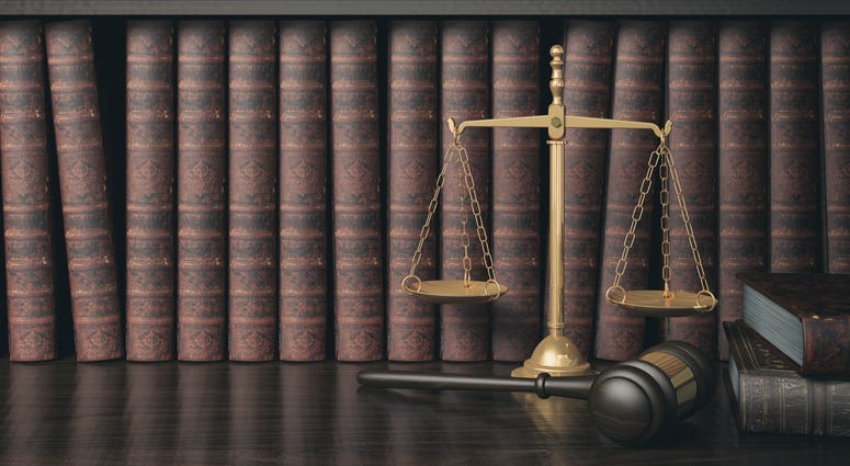 Low key filter law bookshelf with wooden judge's gavel and golden scale