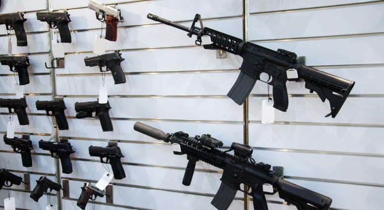 Gun wall rack with rifles and pistols