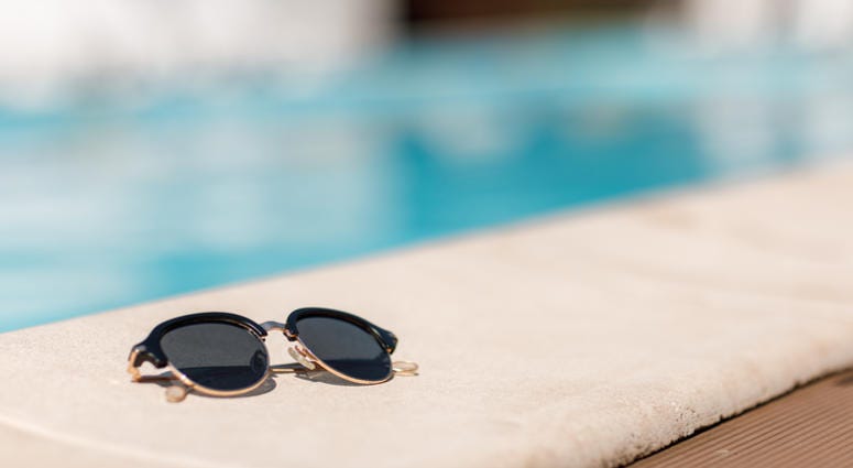 sunglasses by the pool on a sunny summer day