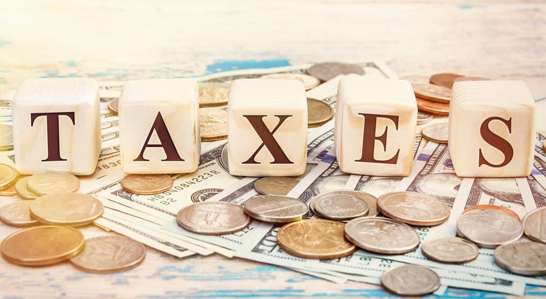 Word "TAXES" written with wooden cubes and money