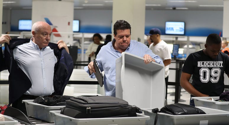 2 men at a TSA checkpoint at an airport