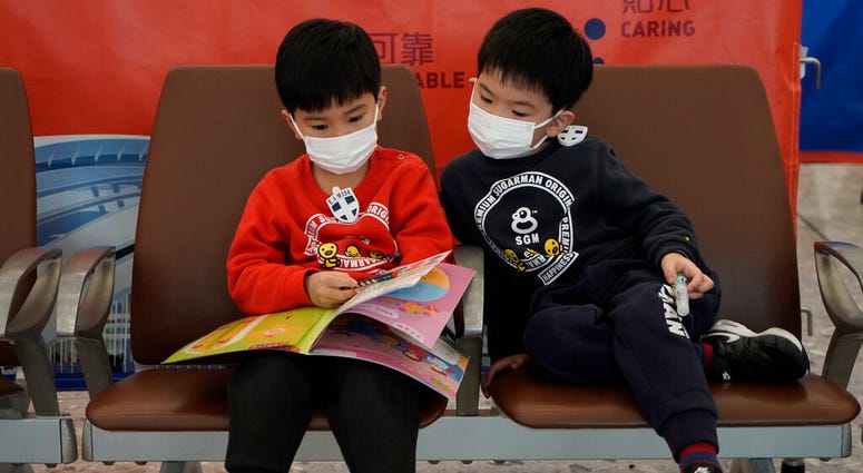Passengers wear masks to prevent an outbreak of a new coronavirus in the high speed train station, in Hong Kong, Wednesday, Jan. 22, 2020.