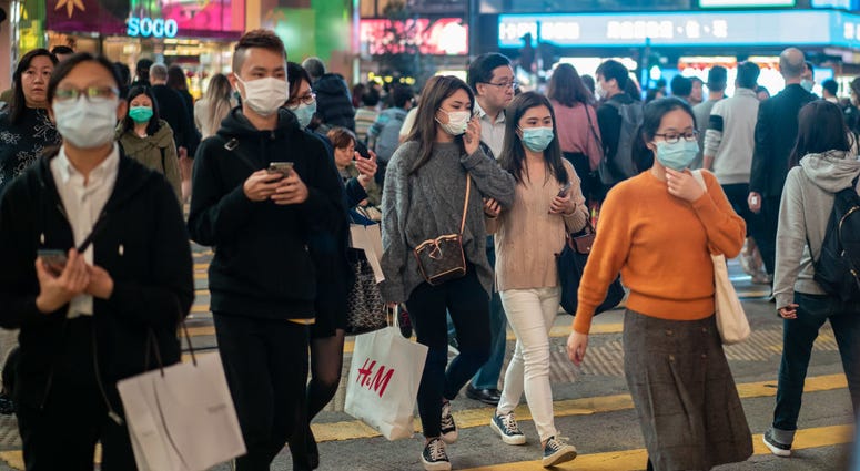 edestrians wear face masks as they walk through a crosswalk in Causeway Bay district on January 23, 2020 in Hong Kong, China.